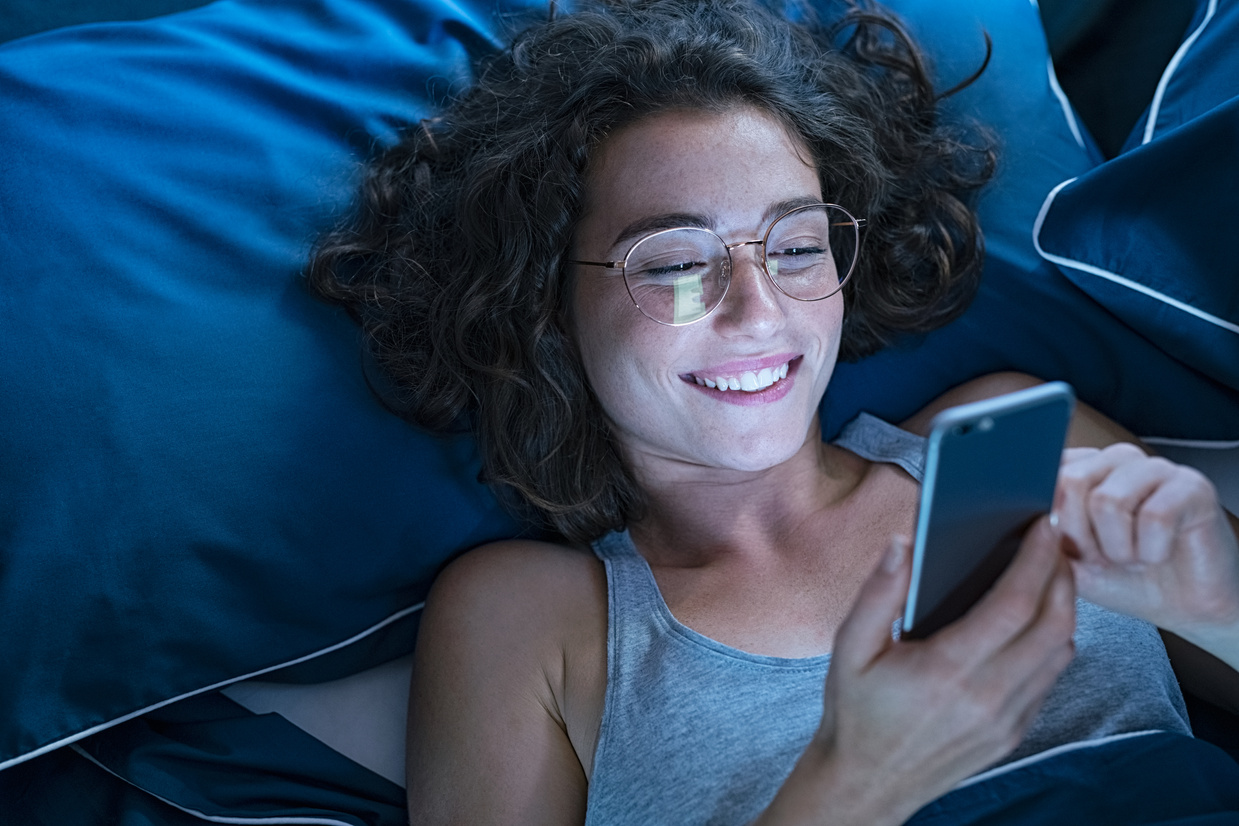 Happy Smiling Woman Using Smartphone Late in Night