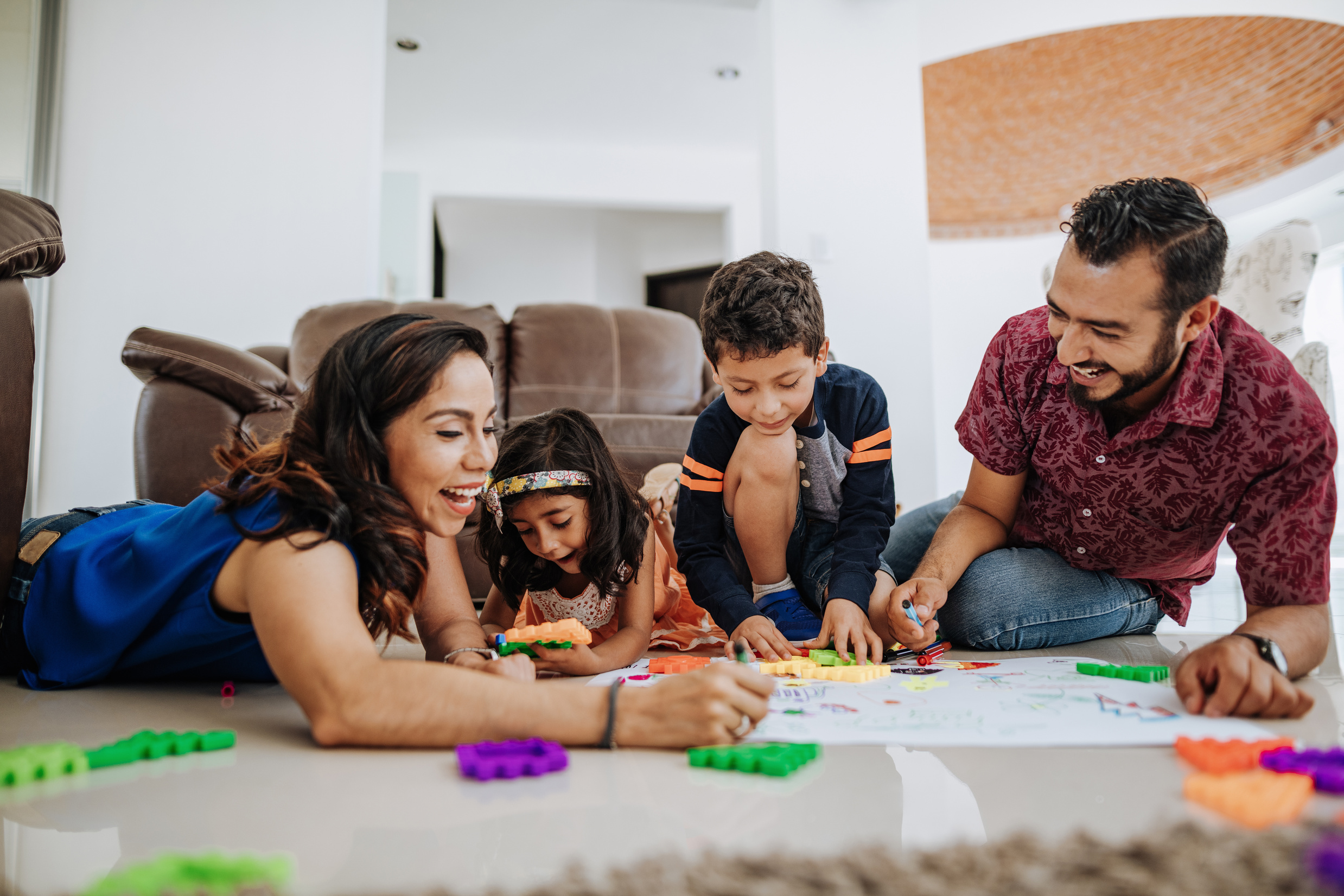 Latino family enjoying being together at home and playing with kids.